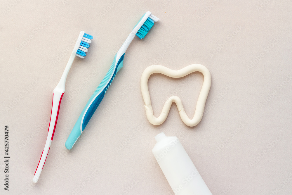 Tooth shape with tube of toothpaste and toothbrush. Dental hygiene concept, top view Tooth shape with tube of toothpaste and toothbrush. Dental hygiene concept, top view
