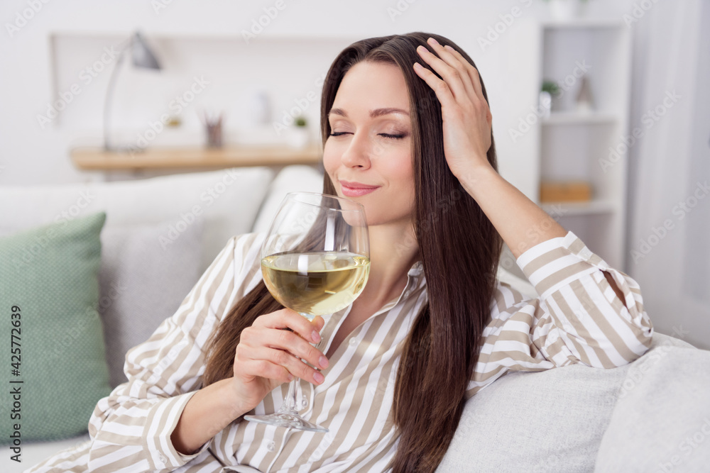 Portrait of attractive dreamy cheerful girl sitting on cozy sofa drinking wine spending free time at home house indoor Portrait of attractive dreamy cheerful girl sitting on cozy sofa drinking wine spending free time at home house indoor