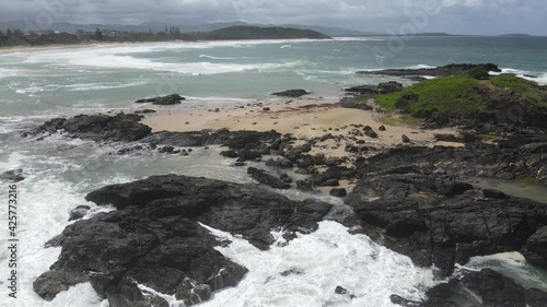 Black Rocky Outcrops At Sawtell Beach With Seascape In Summer - Sawtell, New South Wales, Australia. - aerial photo