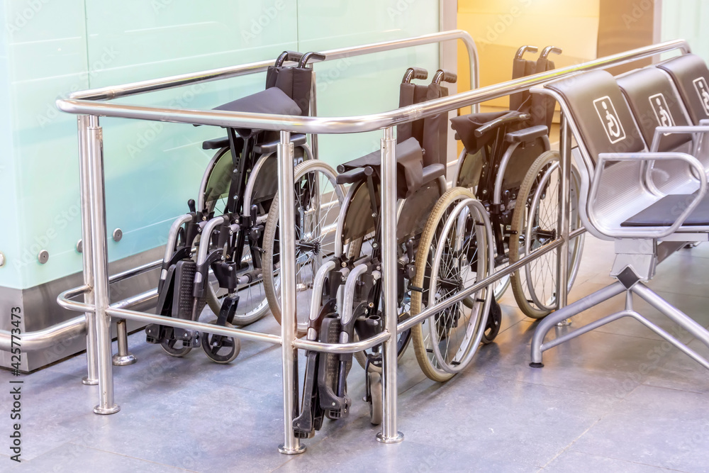 Folded wheelchairs in a public place in the airport terminal building, assistance to people with limited mobility.