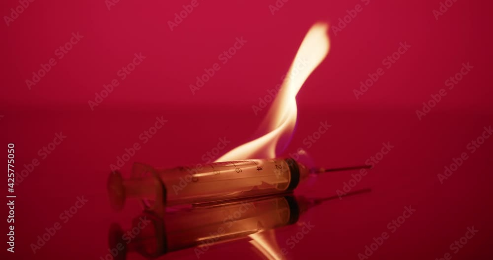 Syringe needle on fire, Red Abstract background. Vaccine, dangerous, biohazard Syringe needle on fire, Red Abstract background. Vaccine, dangerous, biohazard