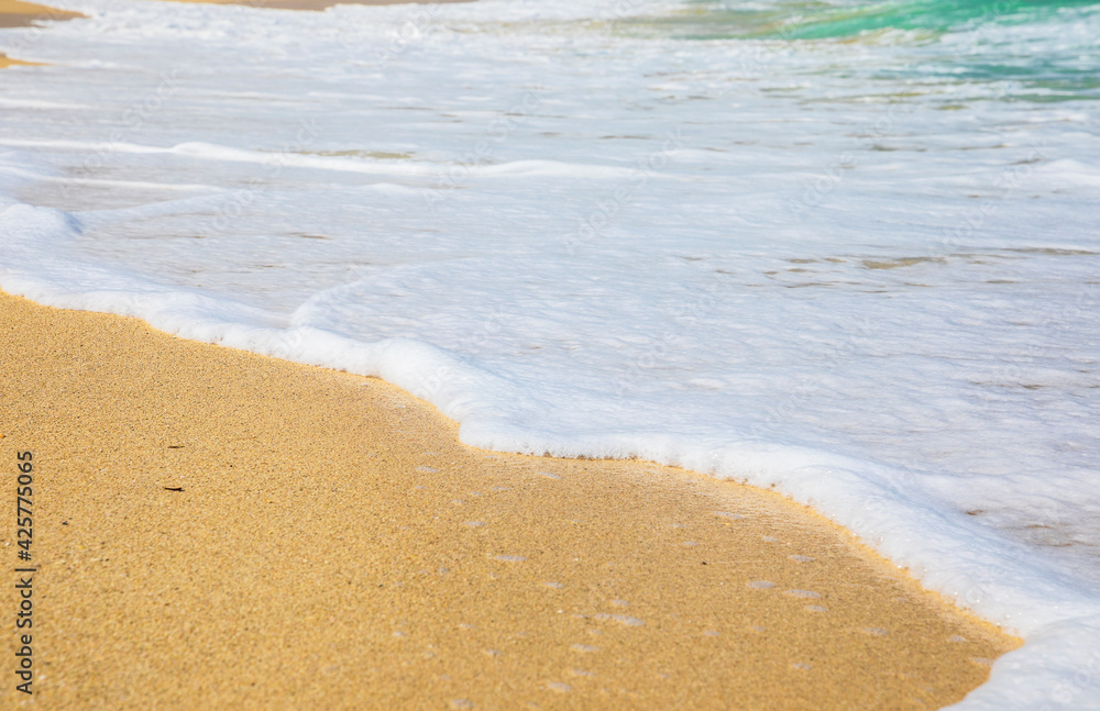 Rolling a wave with foam on a sandy shore Rolling a wave with foam on a sandy shore