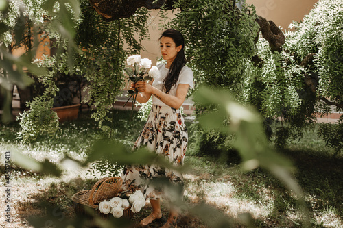 Young beautiful girl with basket of the flowers at  the old villa in the summer. Vintage style