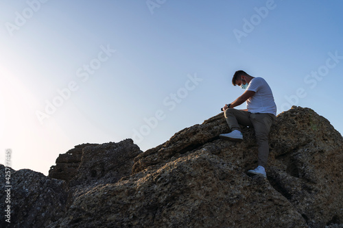  shot of a white Caucasian man walking on the rocks