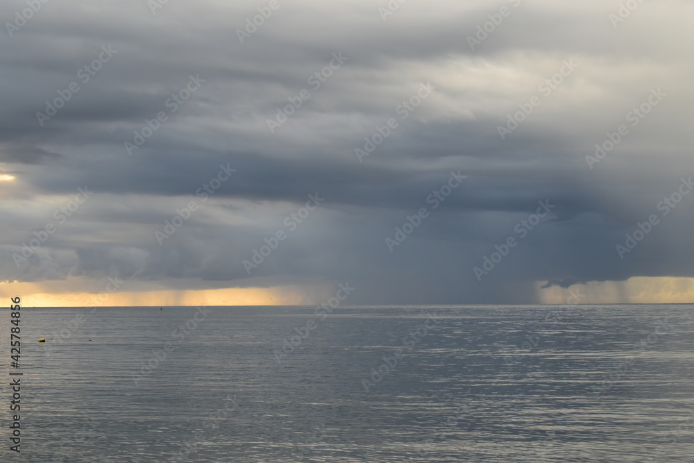 Rain at sea, dramatic clouds on the horizon, beautiful nature.