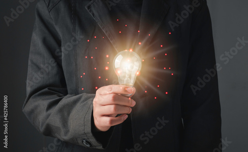 Innovative technology and creativity concept. Close up business man hand holding light bulbs or lamp thinking ideas or new ideas and technology digital line.