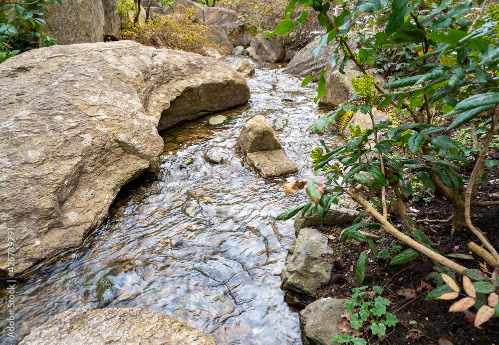 the stream flows among stones and trees