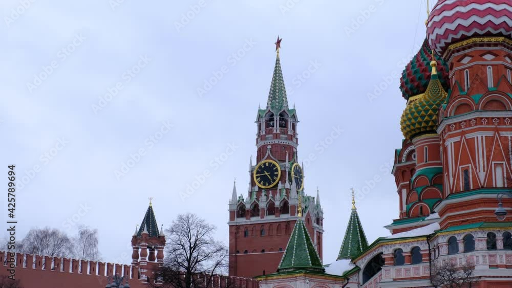 Moscow, Russia 10.02.2021: Red Square in Winter snow holidays time. Spasskaya clock tower through the font of St. Basil's Cathedral Moscow, Russia 10.02.2021: Red Square in Winter snow holidays time. Spasskaya clock tower through the font of St. Basil's Cathedral