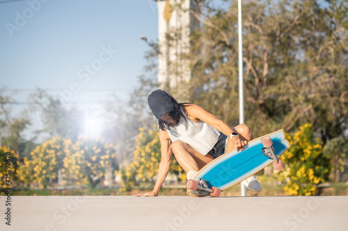 Close-up Asian women surf skate or skates board outdoors on beautiful summer day and was an accident from skating.  © phonix_a