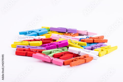 colored small clothes pegs on a white background