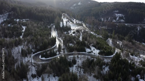 Serpentine road in northern Bavaria over flown by a drone at winter. photo