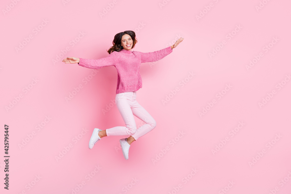 Full size profile photo of optimistic cool brunette lady jump wear pink sweater trousers sneakers isolated on pink background