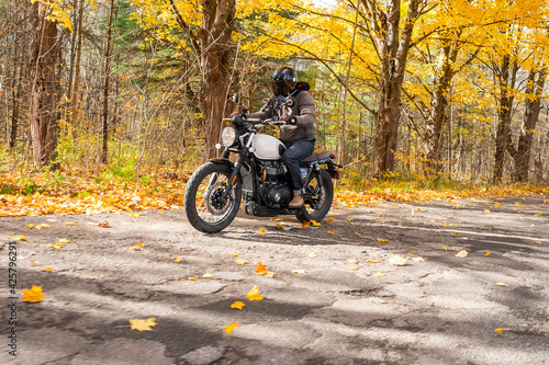 Young man riding his motorcycle in the fall