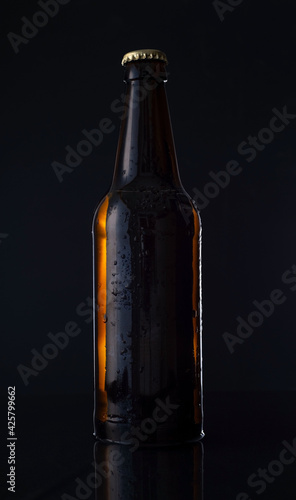 bottle of beer on a black background. Advertising photo