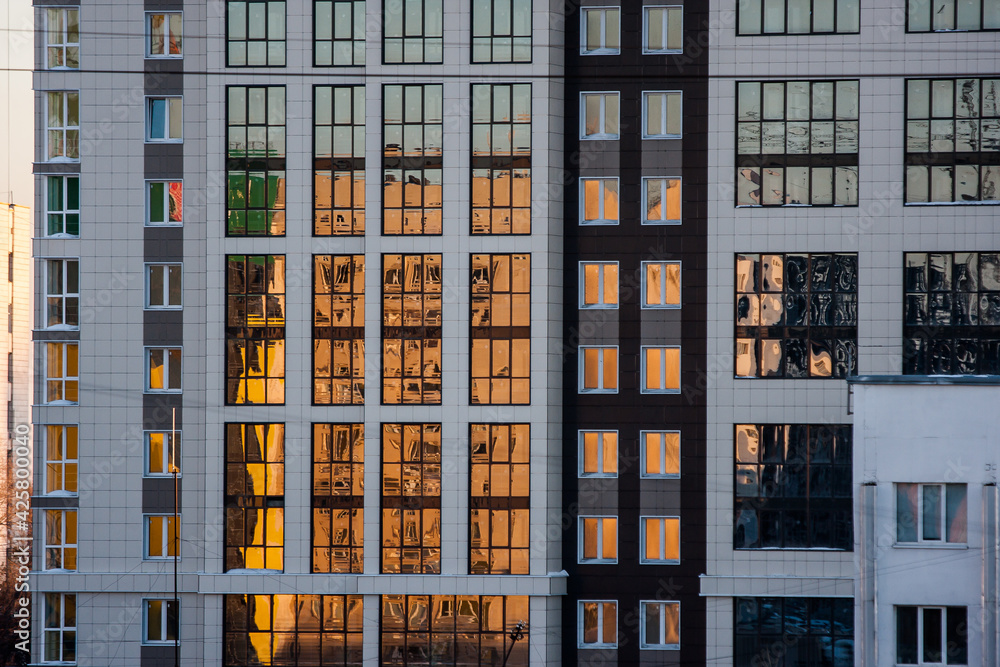 sunset light reflected in the windows of a modern multi-storey building