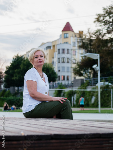 Old and stylish woman on a summer walk in beautiful city.