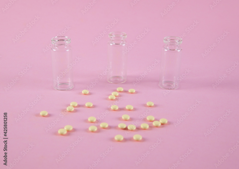 Yellow pills are isolated on pink background. Bottles. Yellow pills are isolated on pink background. Bottles.