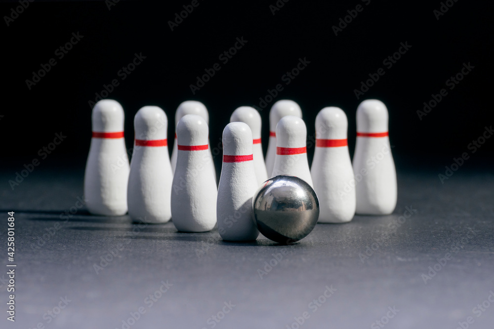 Bowling. Ten pins in white and a ball on a black background. Copy space. Space for text Bowling. Ten pins in white and a ball on a black background. Copy space. Space for text