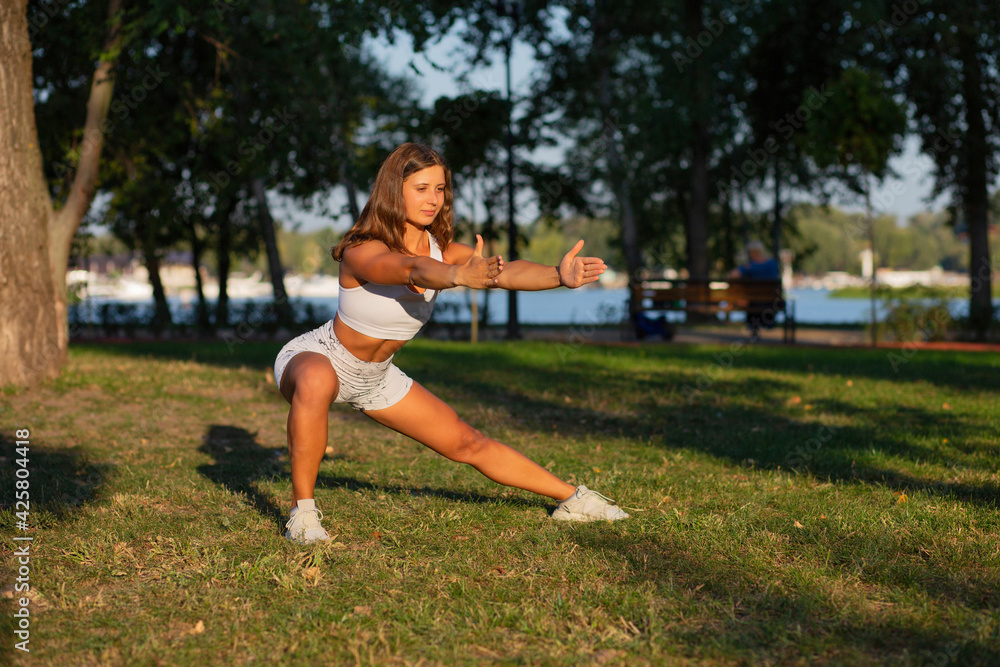 Fit young woman doing pilates workout at the park