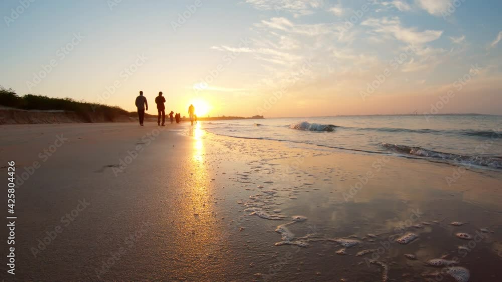 View of the sunset at the beach at Bet Dwarka in Gujarat, India. Summer holiday beach background. Silhouette of people walking on the beach. Travel and Holiday Concept, Summer holiday Relaxation View of the sunset at the beach at Bet Dwarka in Gujarat, India. Summer holiday beach background. Silhouette of people walking on the beach. Travel and Holiday Concept, Summer holiday Relaxation