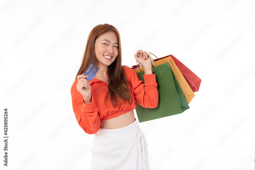 Young beautiful Asian woman smiling happy on white background holding shopping bags. Asian girl in studio, pose feeling happy with shopping bags in studio light portrait.