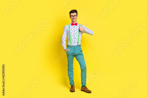 Full length photo of young man happy positive smile show thumb-up great ideal feedback isolated over yellow color background