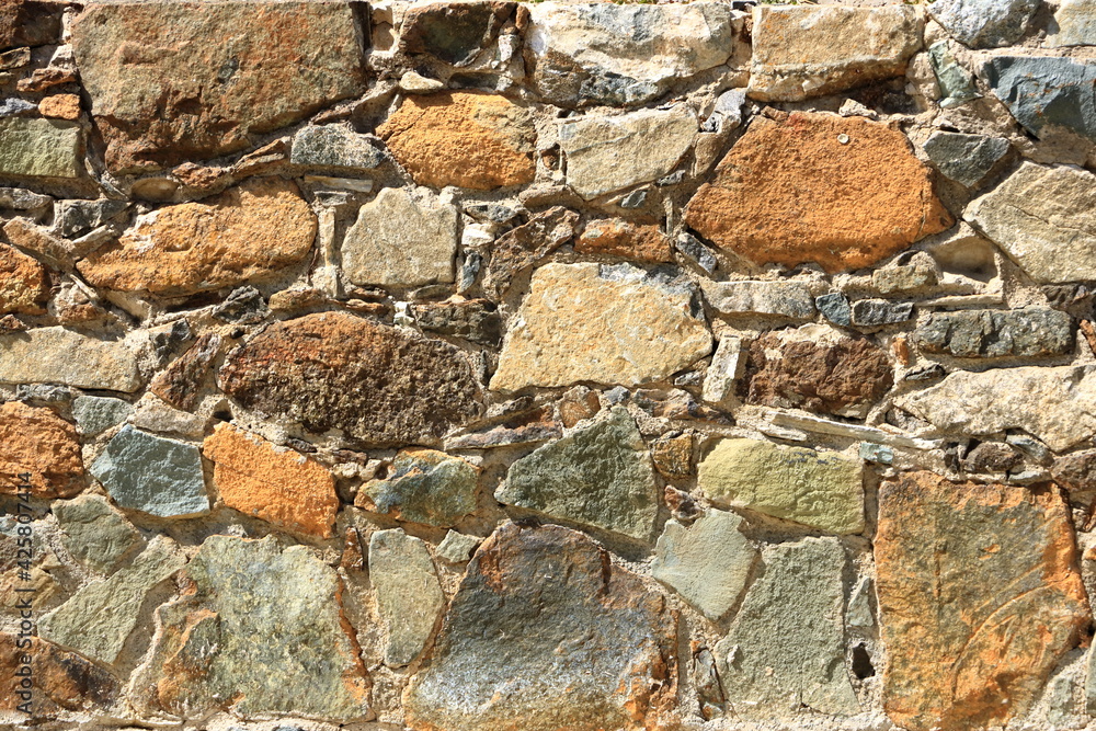 Background of decorate orange green stone wall surface Background of decorate orange green stone wall surface
