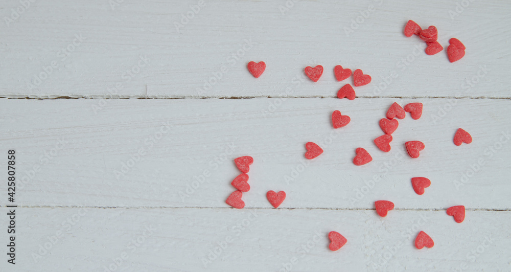 Small red hearts on a white wooden background. Banner for congratulations