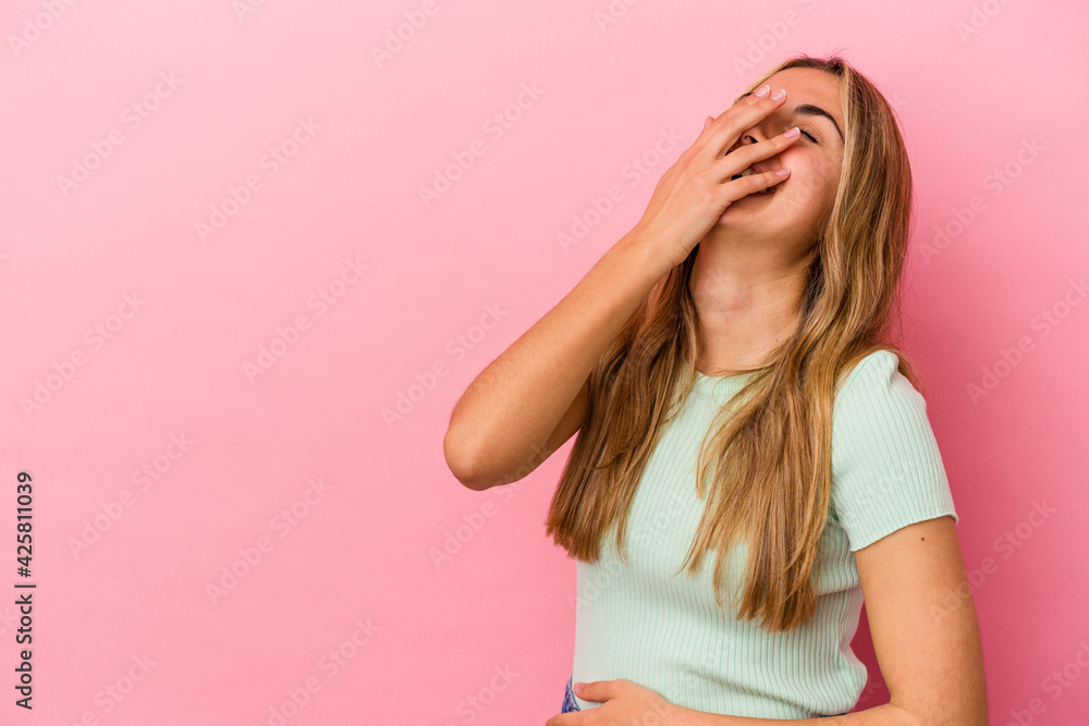 Young blonde caucasian woman isolated on pink background laughing happy, carefree, natural emotion. Young blonde caucasian woman isolated on pink background laughing happy, carefree, natural emotion.