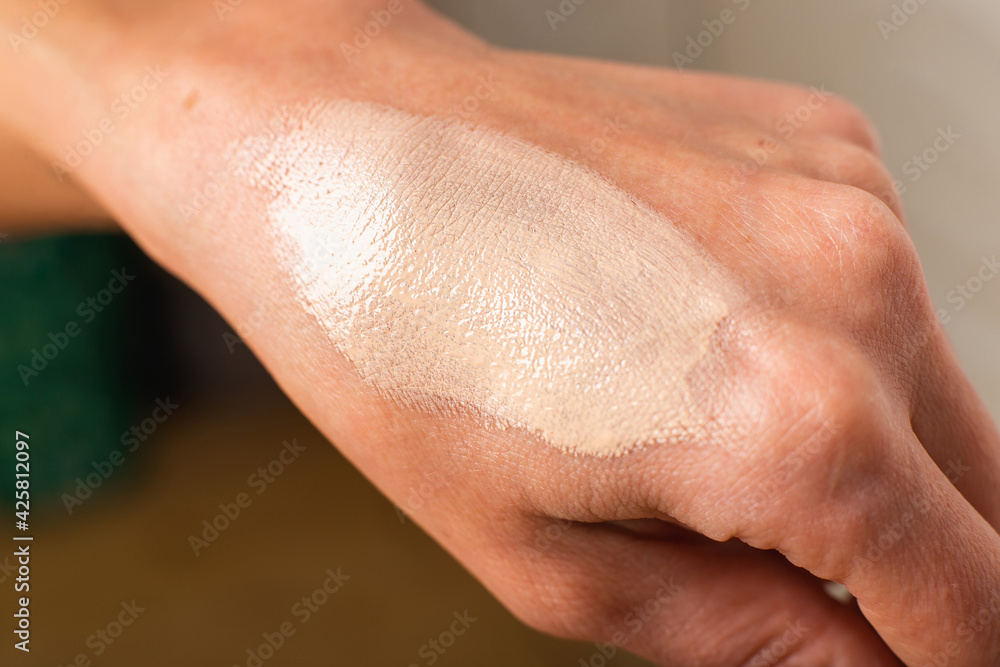 Fototapeta premium Swatch of tonal foundations on the woman hand closeup texture