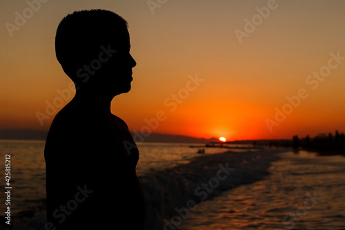 silhouette of child at sunset at sea