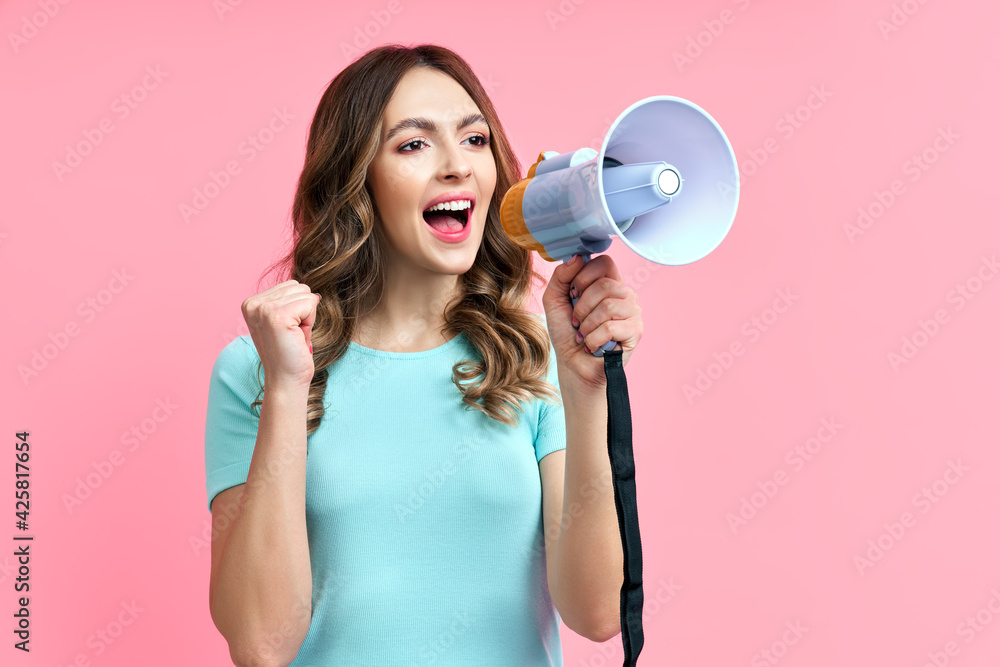Pretty young woman shouting in megaphone on pink background Pretty young woman shouting in megaphone on pink background