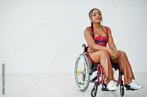 Leinwand Poster Young disabled African American woman in wheelchair against white wall