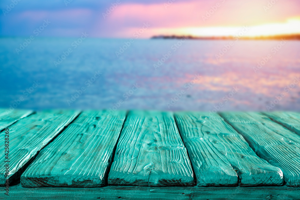 Sunset on the seashore and wooden table in the evening  - obrazy, fototapety, plakaty 