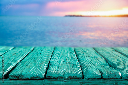 Sunset on the seashore and wooden table in the evening 