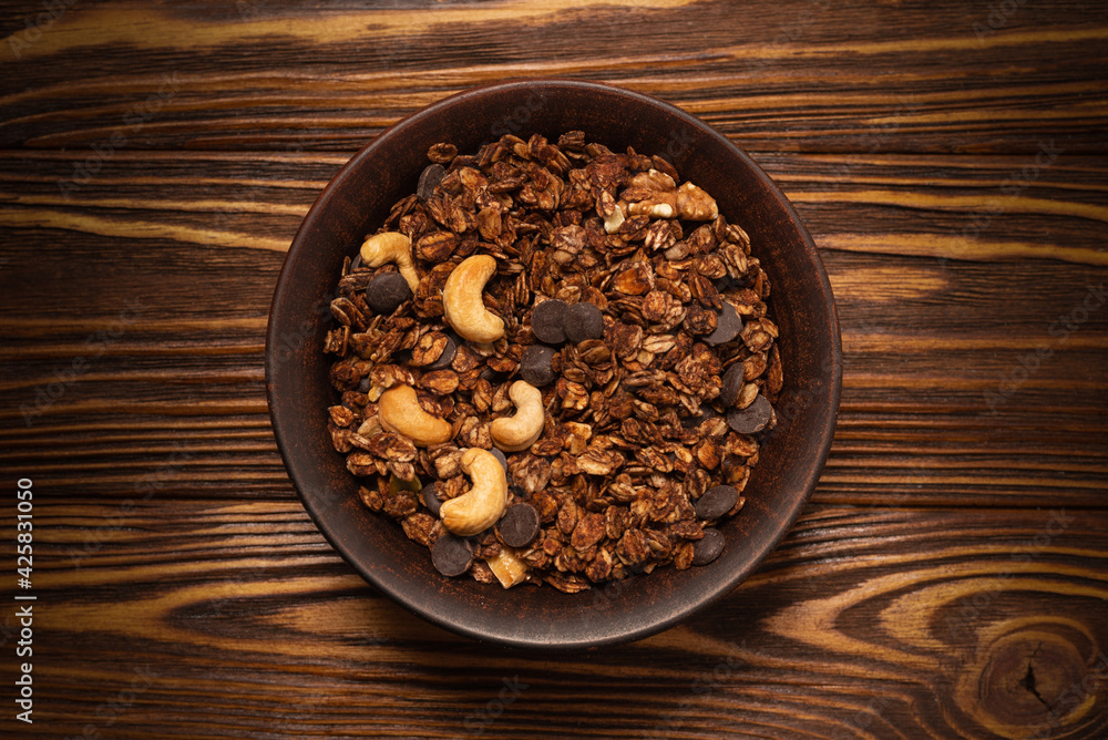 Chocolate granola cereal with nuts in a bowl. Chocolate granola cereal with nuts in a bowl.