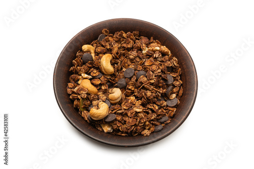 Chocolate granola cereal with nuts in a bowl background.