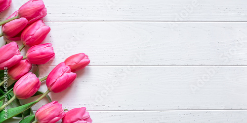 Fresh tulip flowers on a white wooden background. Bright spring background. Copy space for text.
