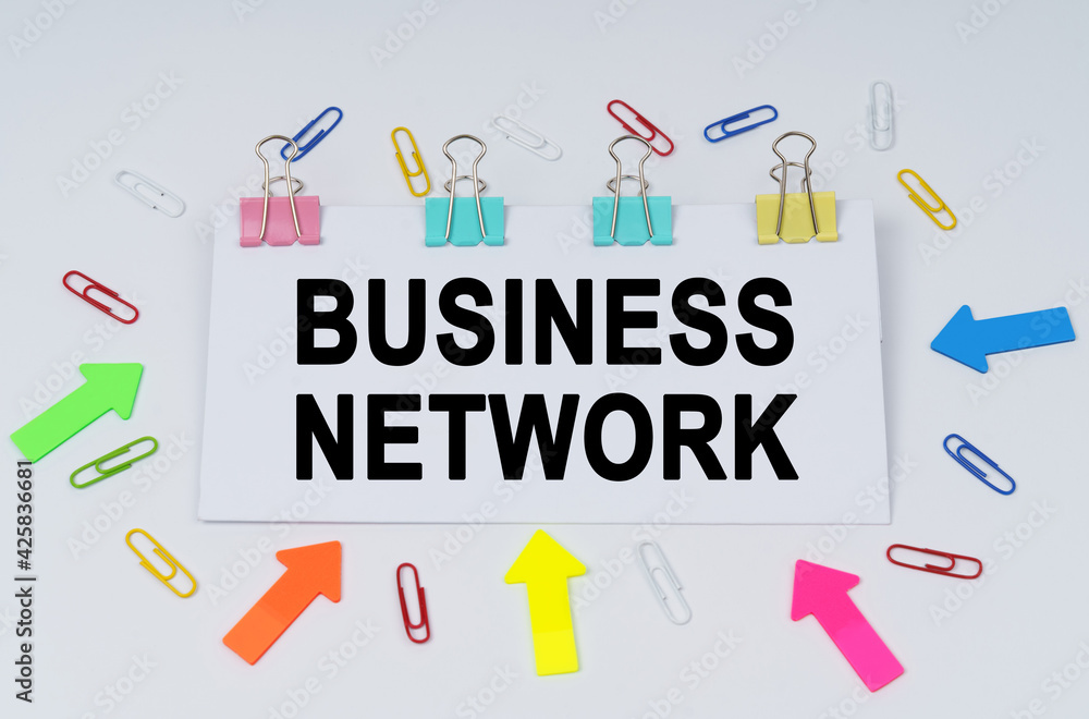 On the table there are paper clips and directional arrows, a sign that says - Business Network On the table there are paper clips and directional arrows, a sign that says - Business Network