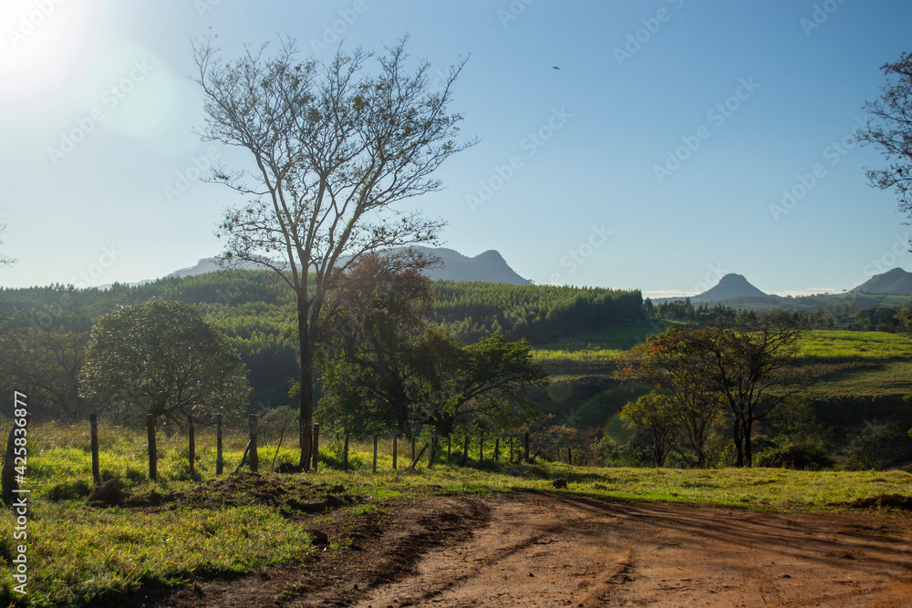 rural area in the dawn sun with small mountains in the background