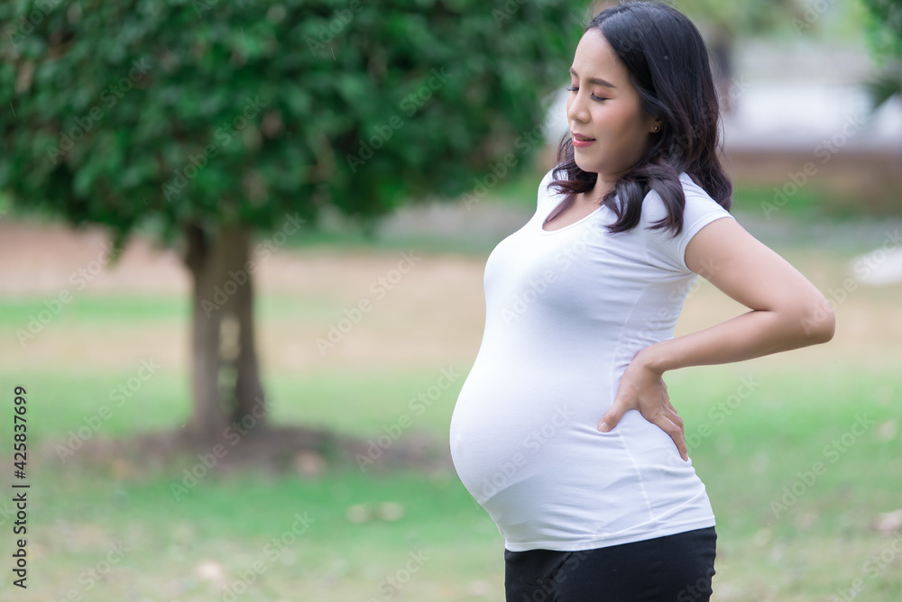 Portrait of asian Beautiful pregnant woman at the park,Thailand people,Happy woman concept,Her use hand touch her belly,Mother day concept Portrait of asian Beautiful pregnant woman at the park,Thailand people,Happy woman concept,Her use hand touch her belly,Mother day concept