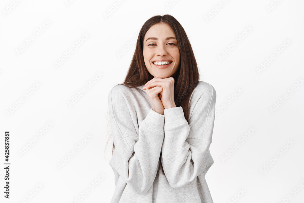 Romantic and cute girl looking with admiration and sympathy, admire something, watching beautiful lovely scene, resting head on hands and smiling, standing over white background Romantic and cute girl looking with admiration and sympathy, admire something, watching beautiful lovely scene, resting head on hands and smiling, standing over white background