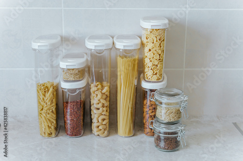 A variety of pasta, rice, cereals, nuts in containers-cans. The concept of proper convenient rational storage of food in the kitchen