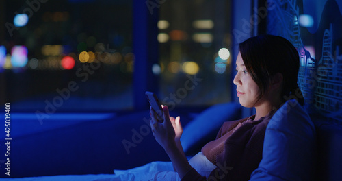 Woman use of smart phone on bed at late night