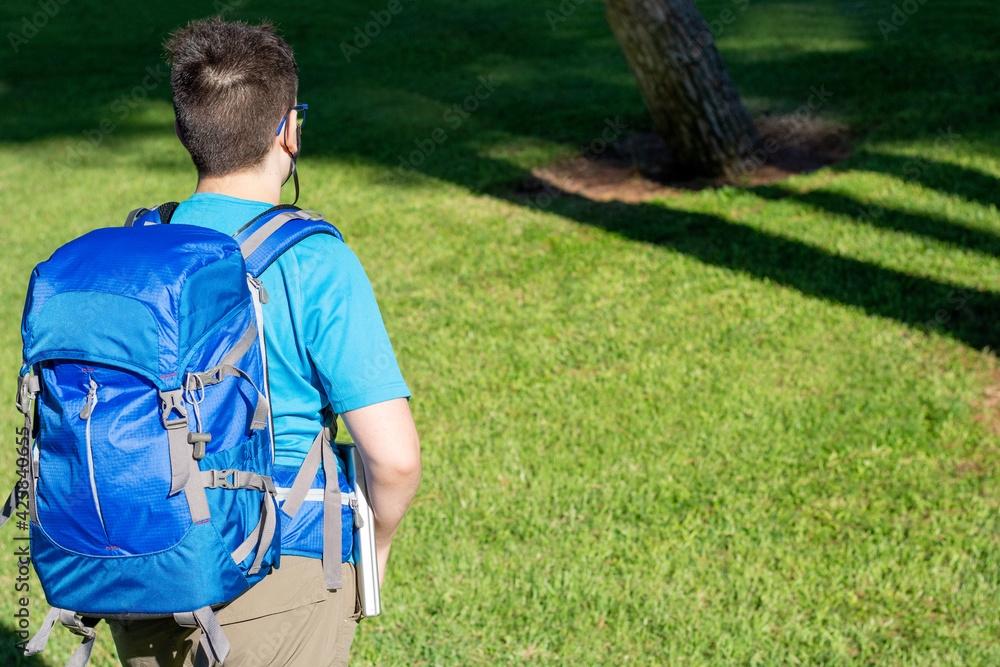 Naklejka premium young man walking in the forest. digital nomad concept.