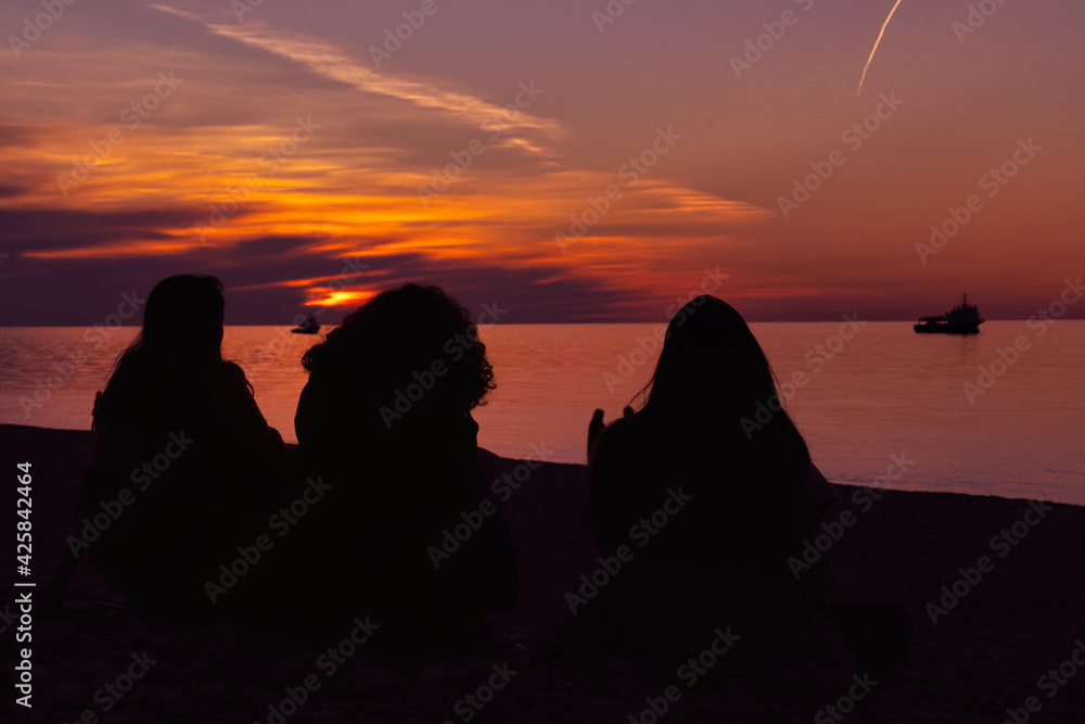 Silhouettes of girls on the background of sunset
