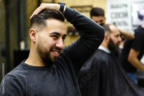 Barbershop. Master hairdresser makes hair and cuts beard