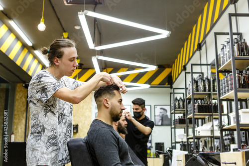 Barbershop. Master hairdresser makes hair and cuts beard