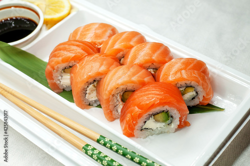 Philadelphia sushi made with fresh raw salmon, cream cheese and avocado. Rolls in a plastic container for delivery. Delicious healthy food.
