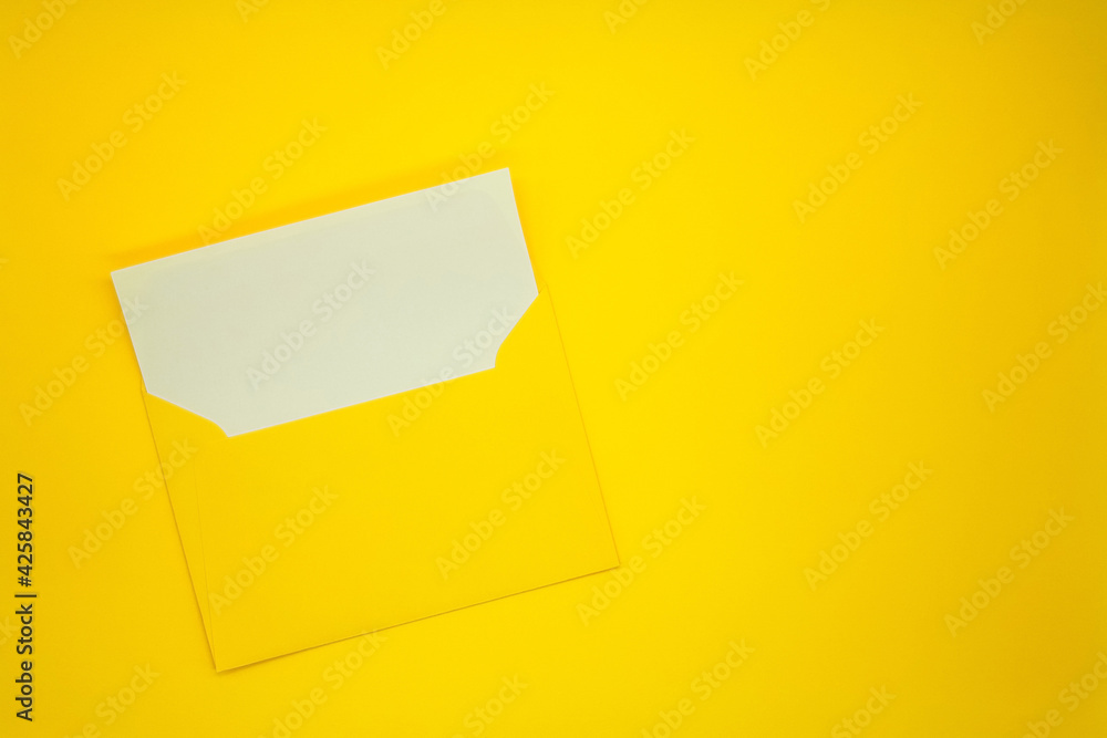 One yellow envelope with a blank white card. Yellow background. Mockup with envelope and blank card. Space for text. One yellow envelope with a blank white card. Yellow background. Mockup with envelope and blank card. Space for text.